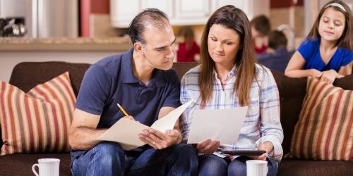 Latin descent couple paying monthly bills at home.