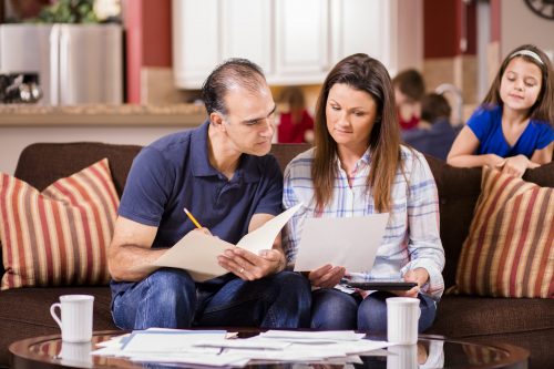 Latin descent couple paying monthly bills at home.