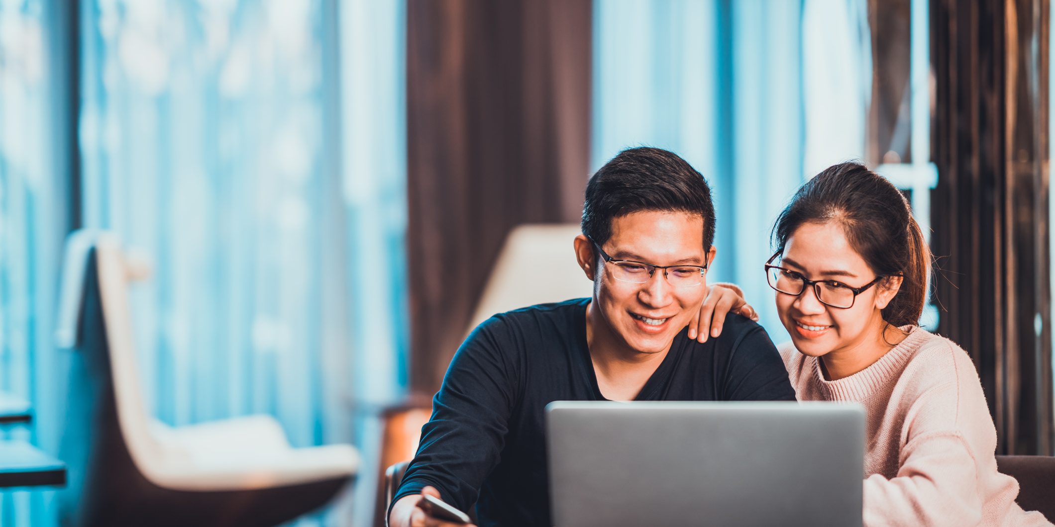 Young Asian married couple working together using laptop at home or modern office with copy space. Startup family business, SME entrepreneur, business partner, love relationship, or freelance concept Owners corporation works